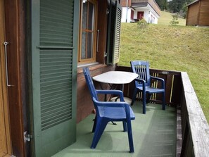 An outdoor seating area with a table and two chairs. - Brandegg 4 Appartement/Fewo, Dusche oder Bad, WC 5-Bett-Wohnung by Interhome (Lenk)