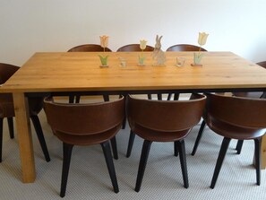 Una mesa de comedor de madera con seis sillas, cada una con asiento de cuero marrón.