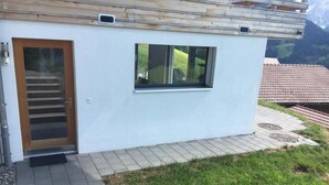 A modern building with a wooden door, a window, and a set of stairs leading to the entrance. - Chalet Coco Appartement/Fewo, Dusche, WC, 3 Schlafräume 6-Bett-Wohnung by Interhome (Lenk)