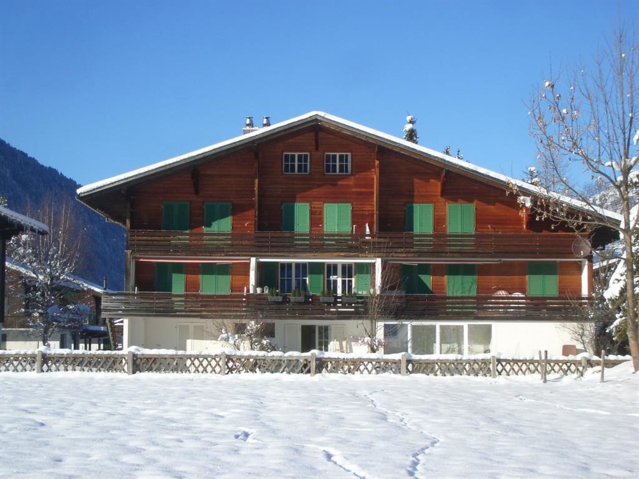 Ein zweistöckiges Holzhaus mit Balkon, umgeben von Schnee.