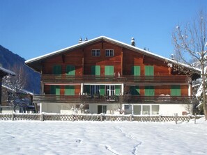 A two-story wooden building with a balcony, surrounded by snow. - Burgbüel # 1 Appartement/Fewo, Dusche oder Bad, WC, 4 oder mehr Schlafräume by Interhome (Lenk)