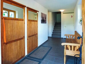 A hallway with wooden doors, a staircase, and a bench. - Lemberg Ferienhaus, Dusche und Bad, WC, 3 Schlafräume 6-Bett-Ferienhaus by Interhome (Lenk)