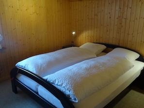 Ein Einzelbett mit Holz Kopfteil in einem Raum mit Holzwänden.