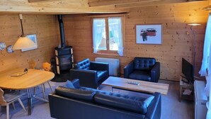A wooden interior with a fireplace, seating area, and a dining table. - Reseda Appartement/Fewo, Dusche und Bad, WC, 2 Schlafräume 4-Bettwohnung by Interhome (Lenk)