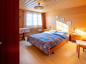 A wooden-paneled bedroom with a bed, a desk, and a chair. - Berna 2. Stock Appartement/Fewo, Bad, WC, 2 Schlafräume 4-Bettwohnung by Interhome (Lenk)