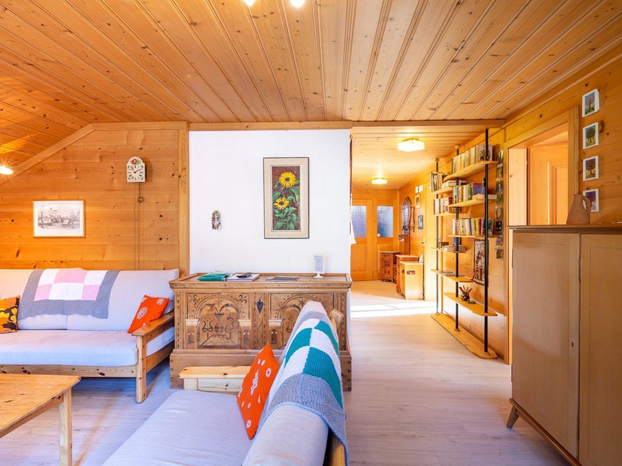Une pièce chaleureuse avec un canapé, un meuble en bois et une bibliothèque.