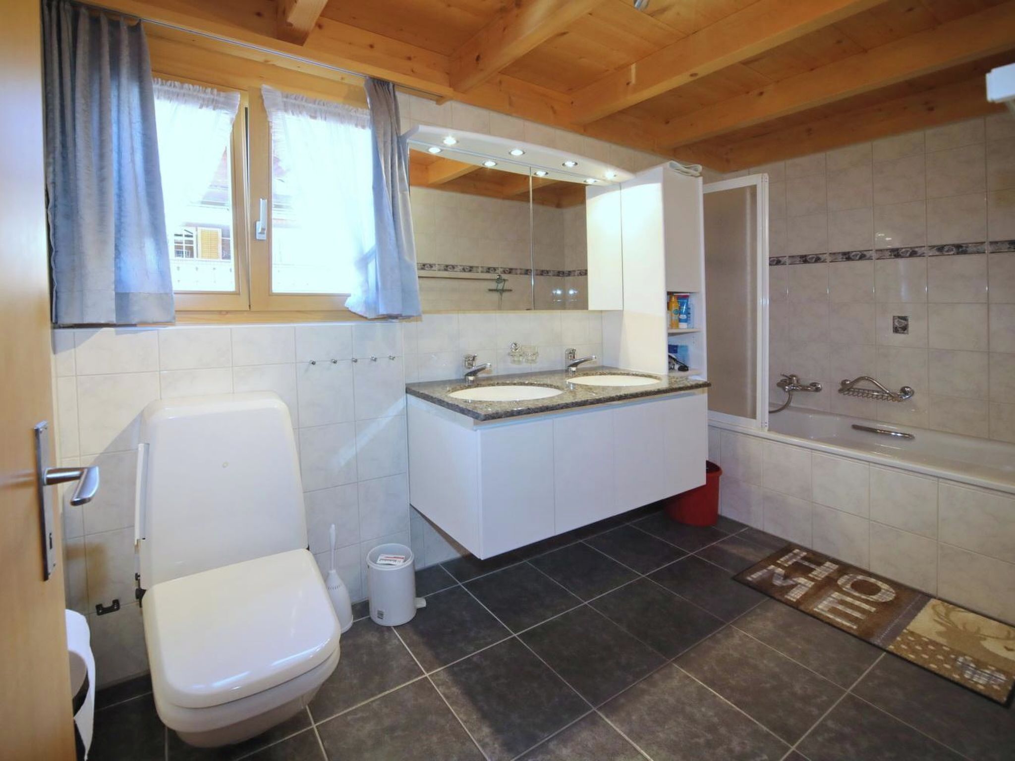 Un bagno con il water, un lavandino, uno specchio e una doccia.
