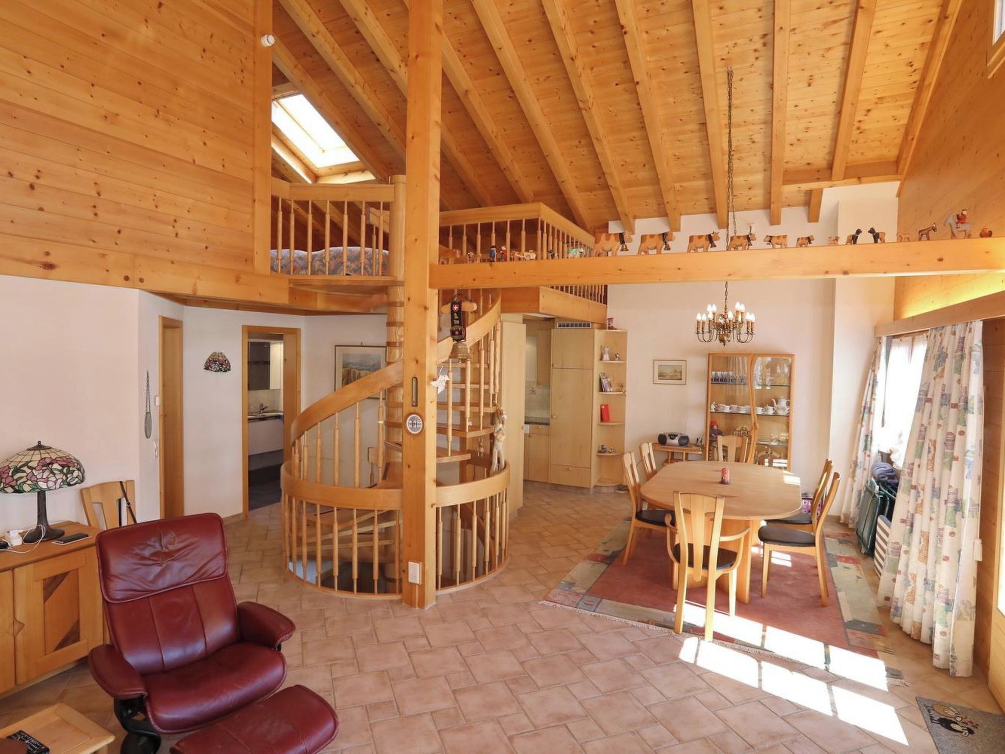 Un vaste espace de vie agrémenté d’un escalier en bois, d’une table à manger avec des chaises et d’un coin salon confortable.