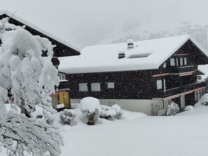 A snow-covered house with a sloped roof, multiple windows, and a chimney. - Lenk Unique Appartement/Fewo, Dusche und Bad, WC, 2 Schlafräume 4-Bettwohnung by Interhome (Lenk)