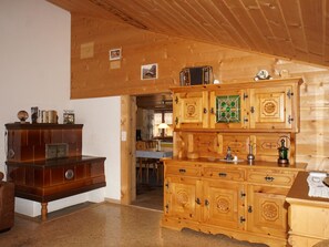 Ein Holzinnenraum mit einem großen Schrank, einem kleineren Schrank und einem Essbereich mit Tisch und Stühlen.