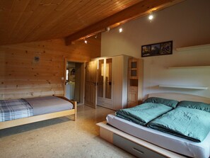 A bedroom with two beds, a wardrobe, and a door leading to another room. - Ferienwohnung Haltenboden Appartement/Fewo, Bad, WC, 2 Schlafräume 3-Bettwohnung by Interhome (Boltigen)