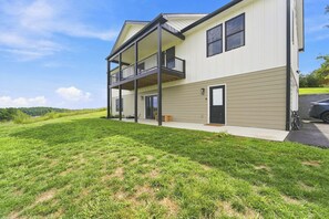 Ein zweistöckiges Gebäude mit Balkon, Garage und Rasenfläche.