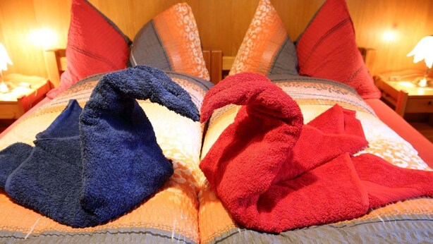 A bed with multiple pillows and a blanket. - Béatrice Appartement/Fewo, Dusche oder Bad, WC, 2 Schlafräume 4-Bett-Wohnung by Interhome (Lenk)