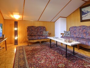 Ein gemütliches Wohnzimmer mit einer Sofagarnitur, einem Couchtisch und einem Schachbrett.