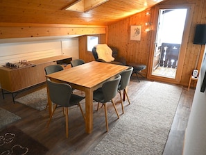 A cozy room with a wooden table and chairs, a chessboard, a sauna, and a large window. - Chalet Waldchutz - Wohnung Anax Appartement/Fewo, Dusche, WC, 2 Schlafräume by Interhome (Lenk)
