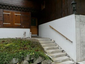 A staircase leading to a wooden door with a metal handrail. - Chalet Waldchutz - Wohnung Anax Appartement/Fewo, Dusche, WC, 2 Schlafräume by Interhome (Lenk)