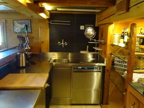 A compact kitchen with stainless steel appliances, a dishwasher, and a small countertop. - Kari's Schüür Appartement/Fewo, Dusche, WC, 2 Schlafräume 5-Bettwohnung by Interhome (Lenk)