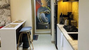 Una cocina estrecha con comedor, pileta y estufa.