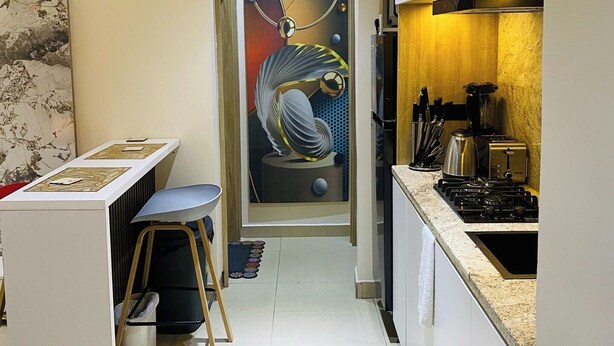 A narrow kitchen with a dining area, a sink, and a stove.