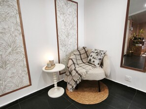 A corner room with a chair, a small table with a lamp, and a mirror on the wall. - Villa panoramic view, air conditioning - 8 guests (Saint-Philippe)