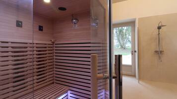 A sauna with wooden slats, a glass door, and a shower area with a glass door.