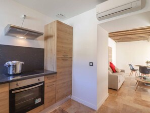 Una cocina moderna con horno empotrado, estufa y una olla sobre la encimera.