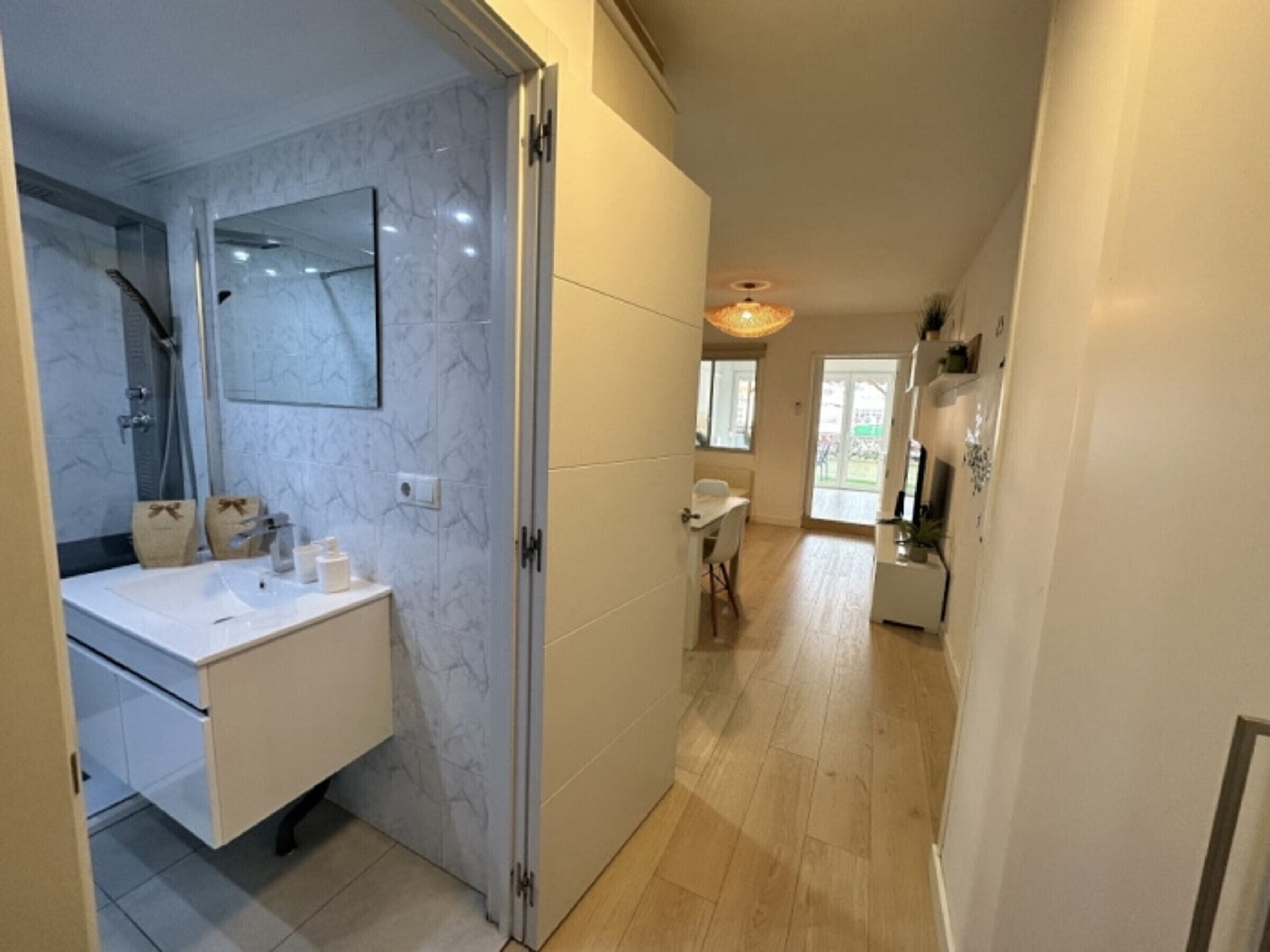Un bagno moderno con una parete in marmo, un lavandino e una doccia.