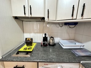 A kitchen with a coffee maker, a kettle, a toaster, and a dish rack on the counter. - Central Apartment with Terrace and Air Conditioning (Torremolinos)