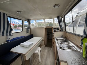 A compact galley with a sink, stove, and a small table with a box on it. - Stay on a boat, port ambiance - 5 guests (Digoin)