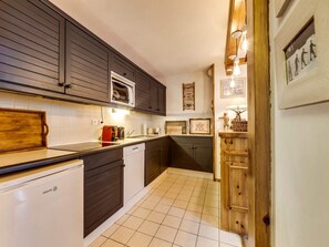 A modern kitchen with dark cabinetry, a built-in microwave, and a dishwasher. - Comfortable apartment at ski slopes - 6 guests (Val-d'Isère)