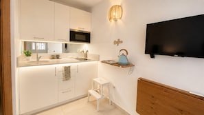 Eine moderne Küche mit Einbau-Mikrowelle, Spüle und einem kleinen Hocker.