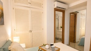 A bedroom with a bed, bedside table, and a mirror. - Beach Getaway with a Pool and Parking (AN)