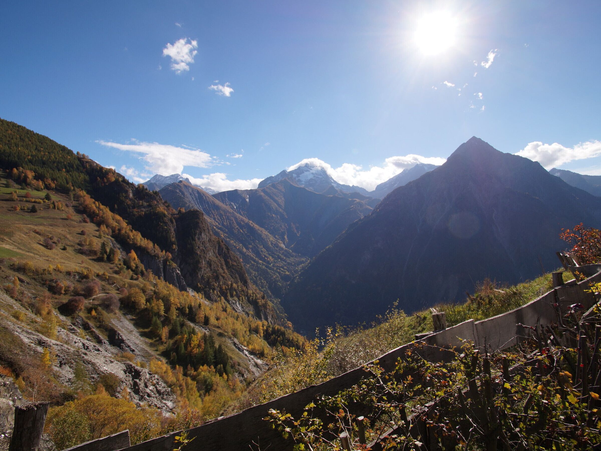 Eine gebirgige Landschaft mit klarem Himmel und einem sonnenbeschienenen Gipfel.