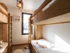 A bunk bed room with a window, a small shelf, and a stuffed toy. - Apartment, glacier view - 6 guests (Les Deux Alpes)
