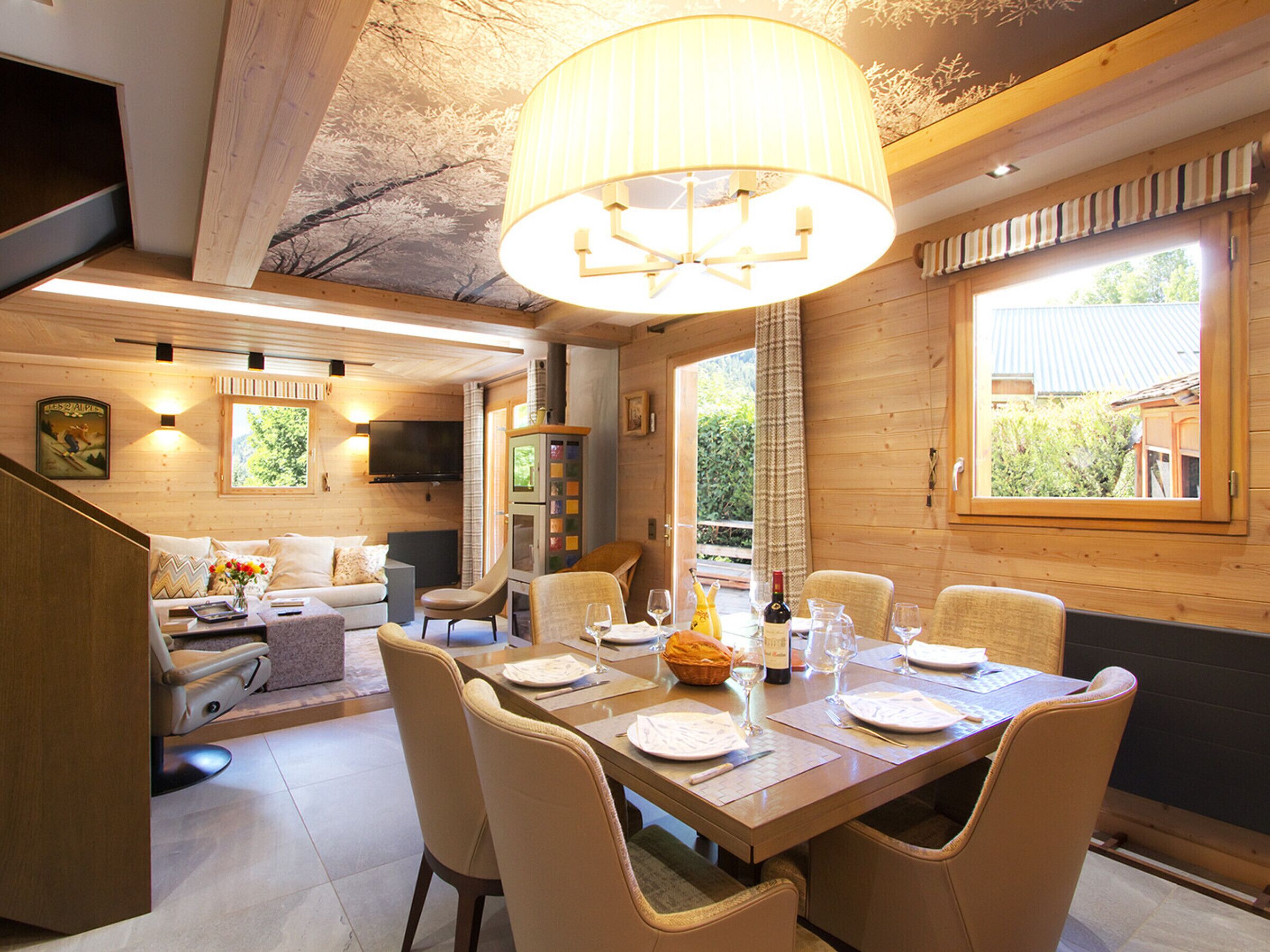 A dining area with a table set for four, a television in the background, and a wooden interior.