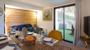 Un comedor con una mesa de madera preparada para una comida, un sofá y un cuadro en la pared.