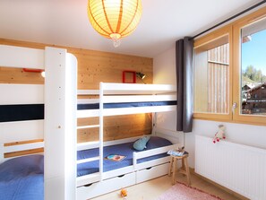 A bunk bed room with a wooden ceiling, a small table, and a window with a view of a mountain. - Charming apartment in the heart of Les Deux Alpes (Les Deux Alpes)