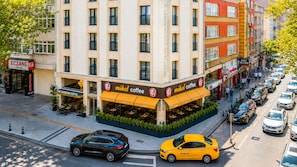 Un edificio de varios pisos con una cafetería llamada 'Mikol Coffee' en la planta baja.