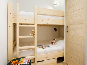 A bunk bed room with a wooden ladder, a teddy bear, and a magazine on the lower bunk. - Bright apartment with parking - 4 guests (Huez)