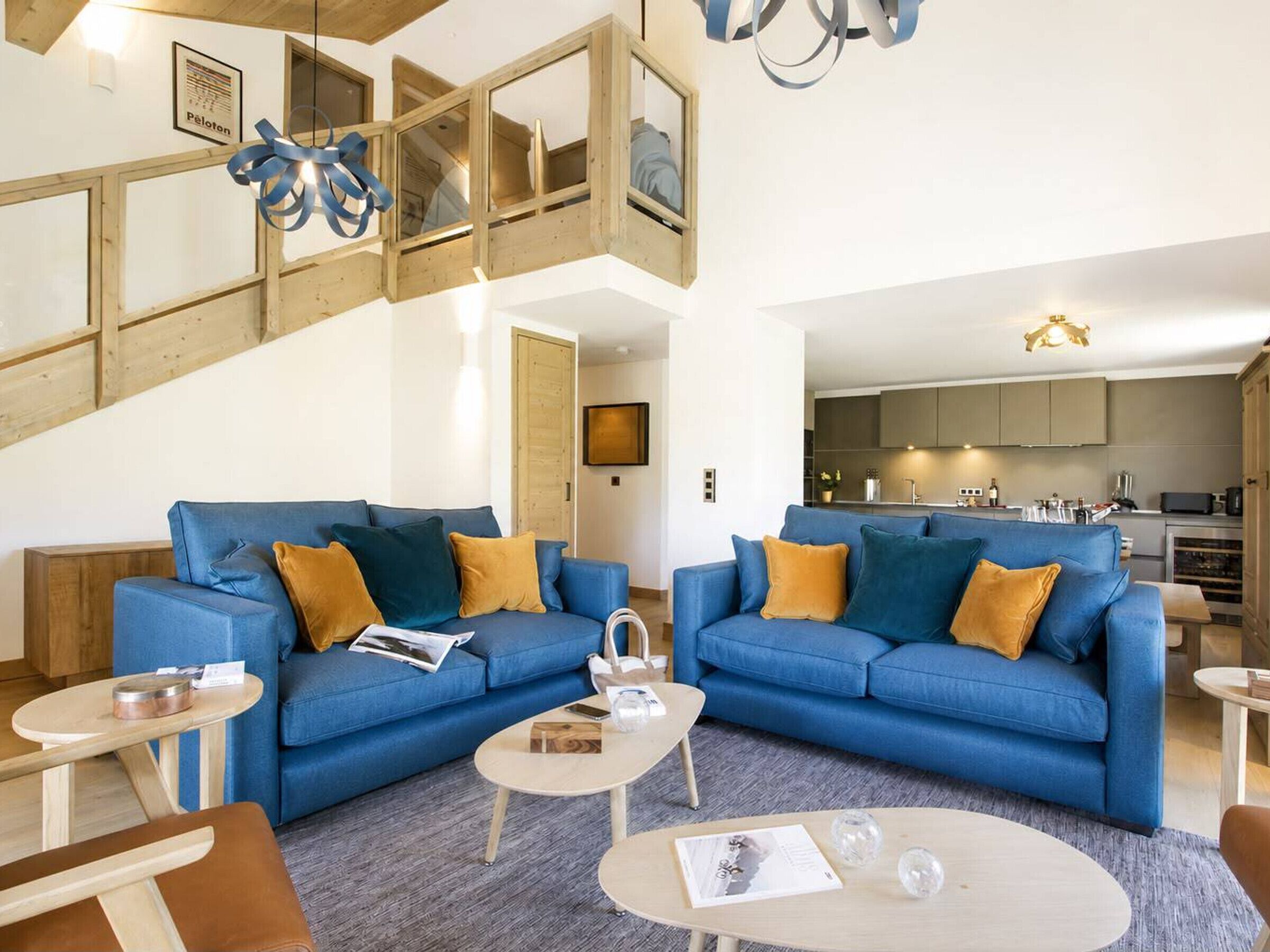 Ein modernes Wohnzimmer mit zwei blauen Sofas, einem Couchtisch und einer Treppe, die in eine obere Ebene führt.