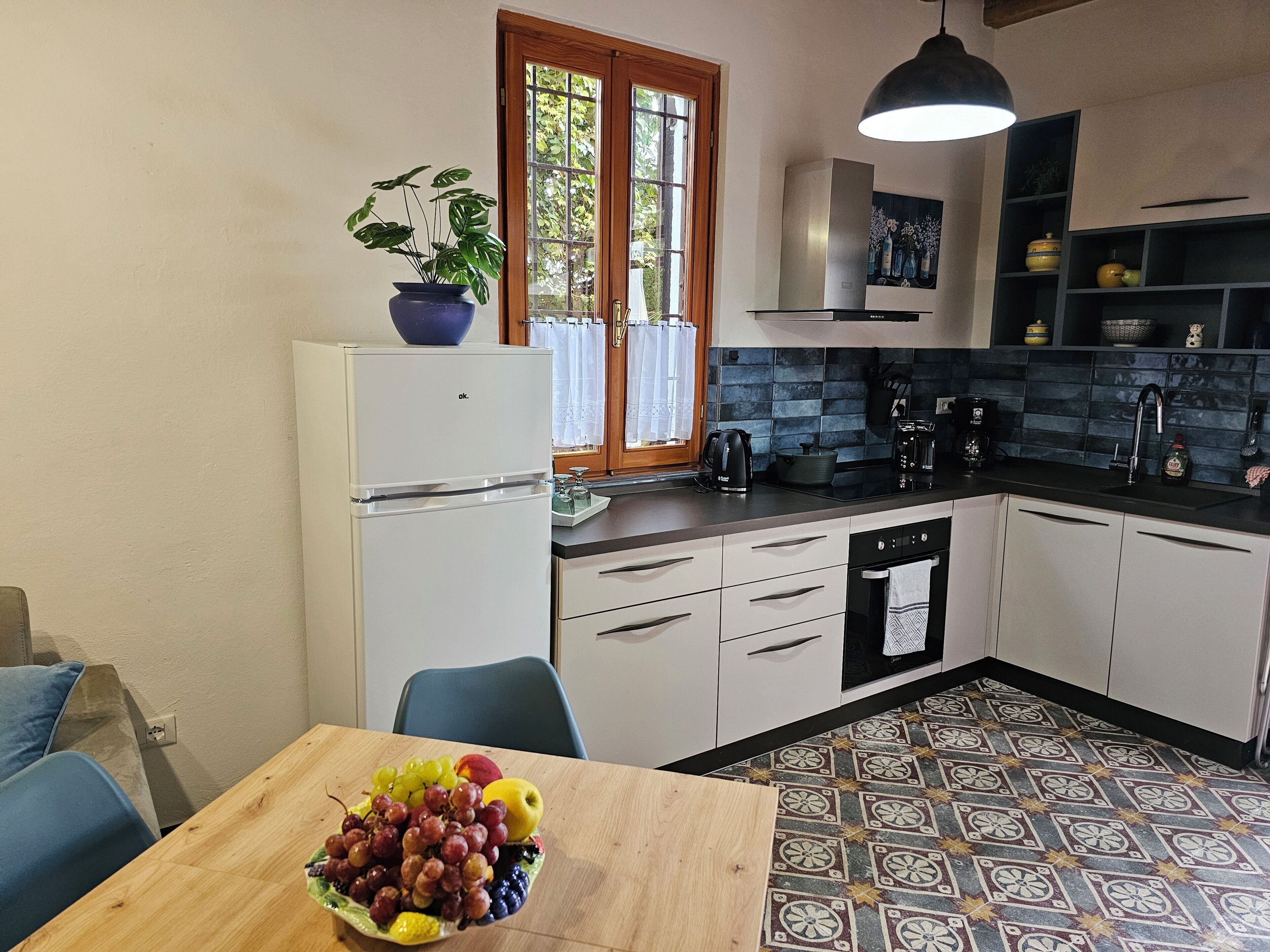 Une cuisine compacte équipée d’un réfrigérateur, d’un évier et d’un coin repas avec une table mise pour le repas.