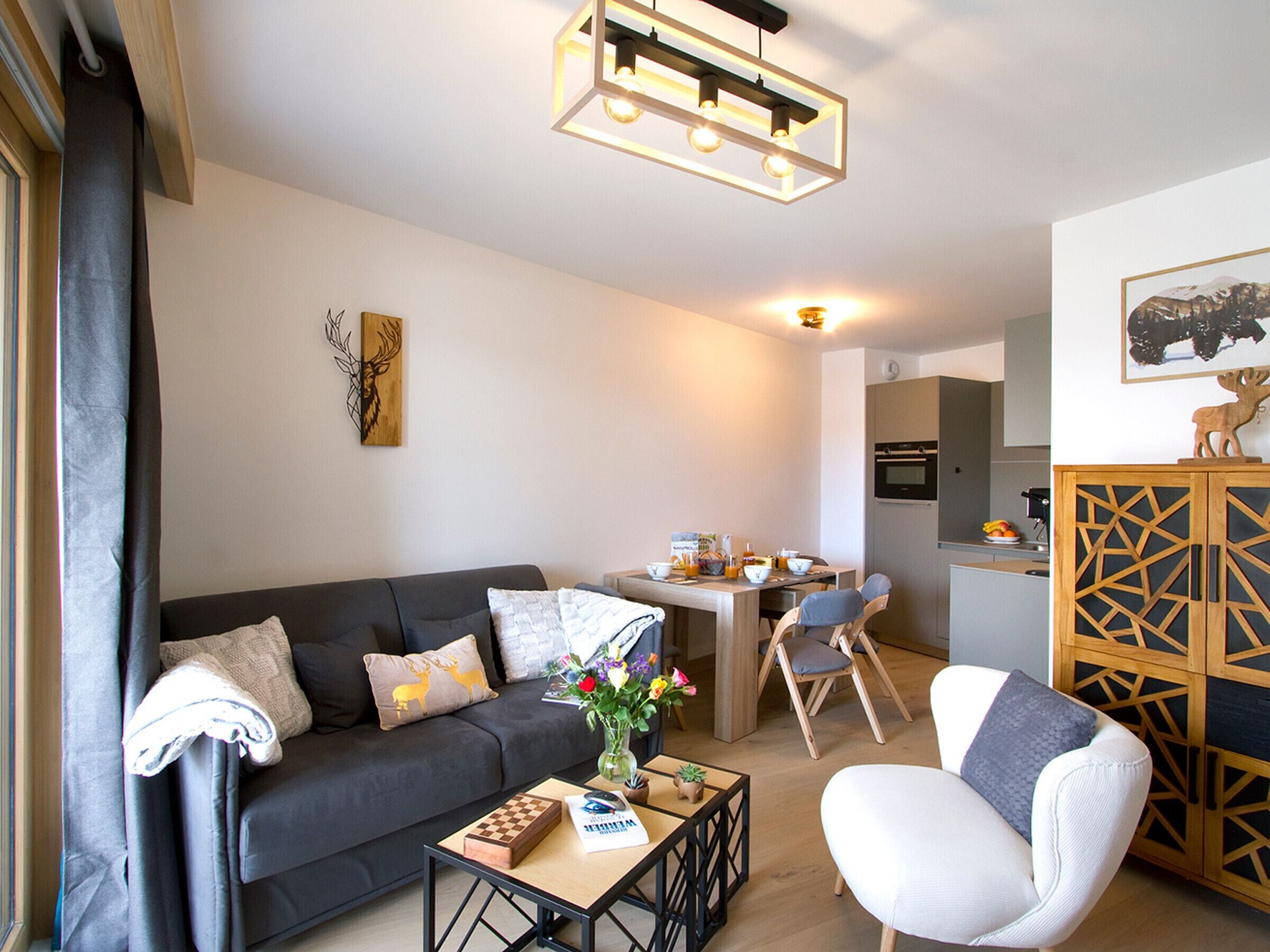Een moderne woonkamer met een bank, salontafel en een eethoek met stoelen.