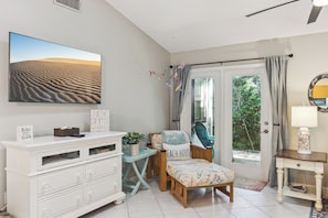 A room with a large window, a white dresser, a bench, and a wall-mounted mirror. - Live Oak Hideway. Sea Woods 3BR Villa in amenity-rich community! (New Smyrna Beach)
