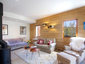 A cozy living room with a sofa, armchair, and a fireplace. - Spacious apartment, terrace, serene - 6 guests (Les Deux Alpes)