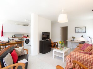Ein modernes Wohnzimmer mit Essbereich, Küche und Sitzgelegenheit.