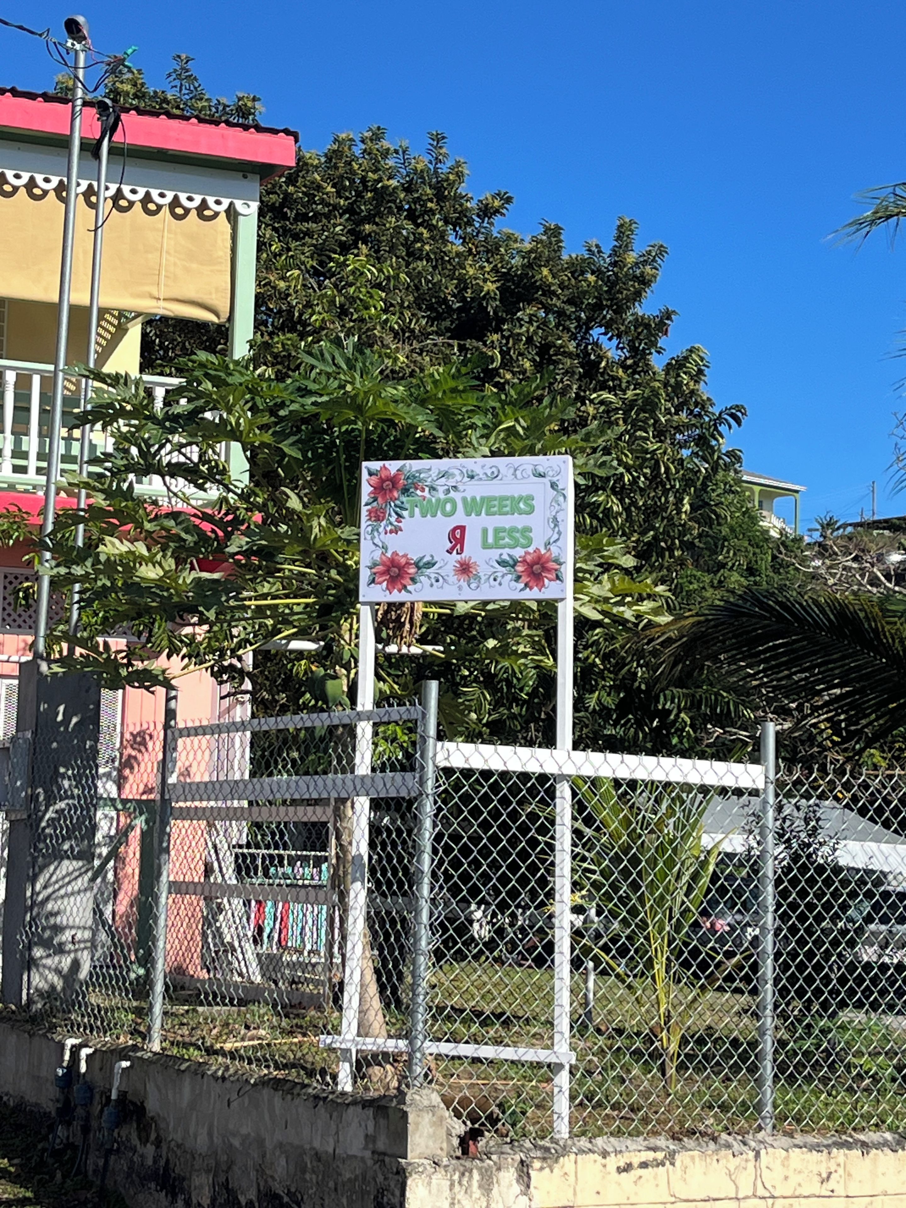 A fenced area with a sign that reads 'TWO WEEKS 9 LESS'.