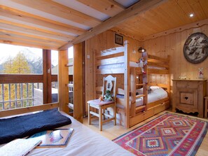 A wooden cabin with bunk beds, a desk, and a chair. - Bright apartment at the foot of the slopes (Les Deux Alpes)