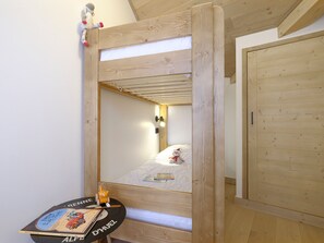 A wooden bunk bed with a mirror, a small table with a book, and a teddy bear on the bed. - Top floor apartment with mountain view - 4 guests (Huez)