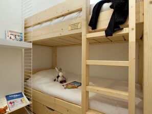 A bunk bed room with a wooden frame, a shelf with a magazine, and a stuffed toy on the lower bunk. - Bright apartment, ski-in/ski-out - 4 guests (Huez)