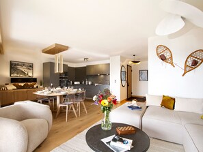 Ein modernes Wohnzimmer mit Essbereich, Küche und einer gemütlichen Sitzecke.